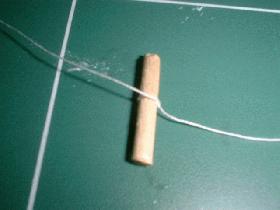 couper un morceau de cure-dent  (1,5 cm) et nouer le fil autour de celui-ci
